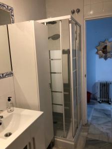 y baño con ducha y lavamanos. en Tablada Los Remedios, en Sevilla