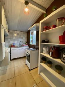 a kitchen with white cabinets and a stove top oven at Pousada do Pescador Eli in Fernando de Noronha