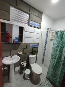 a bathroom with a toilet and a sink at Rancho Ayala II in Santa Marta
