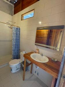 a bathroom with a sink and a toilet and a mirror at Punta Hills Montanita in Montañita