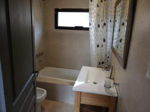 a bathroom with a sink and a tub and a toilet at Casas De Montaña Las Leñas Los Molles in Los Molles