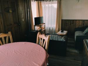 a room with a bed and a couch and a table at Hospedaje Picoyo in Pucón
