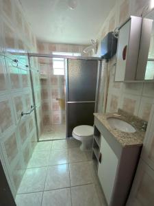 a bathroom with a shower and a toilet and a sink at Hotel Nelly in São Gabriel