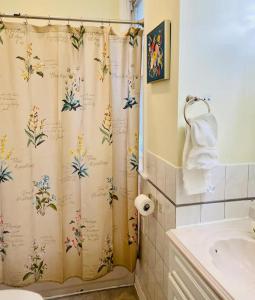 baño con cortina de ducha con flores en Lincoln Park 3 BR Penthouse, en Chicago