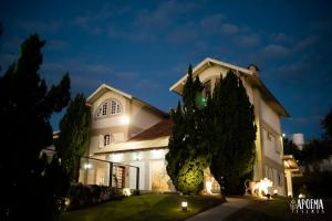 una gran casa blanca por la noche con luces en Mansão Saab casa de campo, en Vinhedo