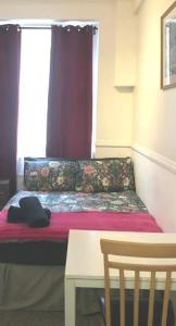 a bed in a room with a window and a table at Private London Kensington studio 2 mins from tube in London