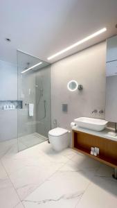 a bathroom with a toilet and a sink and a shower at Radisson Beach Resort Larnaca in Larnaca