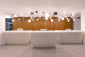 a conference room with white tables and a bunch of lights at Radisson Beach Resort Larnaca in Larnaca