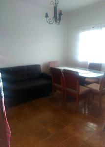 sala de estar con sofá negro y mesa en Casa próximo a praia de Guarapari, en Guarapari