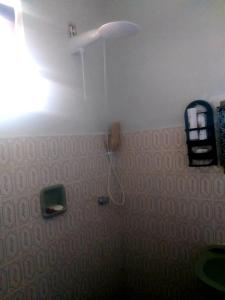 baño con ducha con raqueta en la pared en Casa próximo a praia de Guarapari, en Guarapari