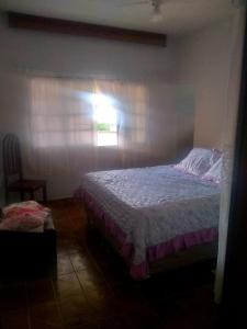 1 dormitorio con cama y ventana en Casa próximo a praia de Guarapari, en Guarapari
