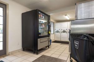 a large black refrigerator in a kitchen next to at Suburban Studios Mentor - Cleveland Northeast in Mentor