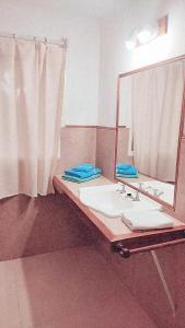 uma casa de banho com um lavatório e um espelho em Las Marukas em San Antonio de Areco