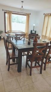 uma sala de jantar com uma mesa de madeira e cadeiras em Las Marukas em San Antonio de Areco