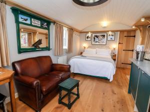 a bedroom with a bed and a leather couch at Amy Johnson in York