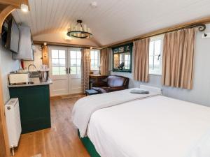 a bedroom with a large bed and a kitchen at Amy Johnson in York