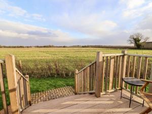a wooden deck with a table and a view of a field at Amy Johnson in York