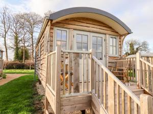 a wooden cabin with a large door and a porch at Amy Johnson in York