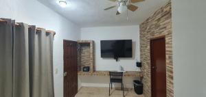 a living room with a television and a chair at Hotel posada MARCAS in Canc&uacute;n