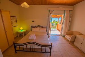 a bedroom with a bed and a door to a patio at Sotiris Studios in Svoronata