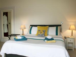 a bedroom with a large white bed with towels on it at Bookkeepers Place in Bakewell