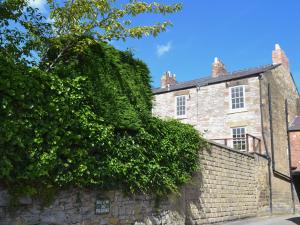 an old stone building with ivy on a wall at Bookkeepers Place in Bakewell