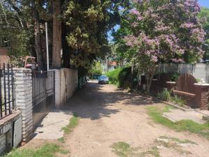 un camino de tierra con una valla y un coche en él en Casa en Carlos Paz en Villa Carlos Paz