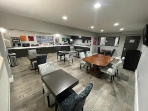 a dining room with tables and chairs and a kitchen at Countryside Inn & Suites Omaha East-Council Bluffs IA in Council Bluffs