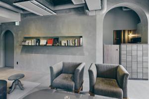 twee stoelen in een kamer met een boekenplank bij Korinkyo in Kanazawa