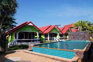 a house with a swimming pool in front of it at Nature Beach Resort, Koh Lanta in Ko Lanta