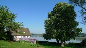 a thatched cottage on the shore of a lake at La Bonne Auberge in Vieux-Port