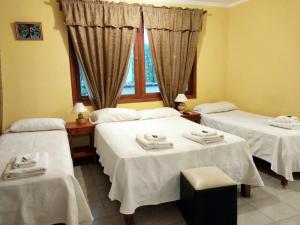 a room with two beds and a window at Benitez Hostería in Calilegua