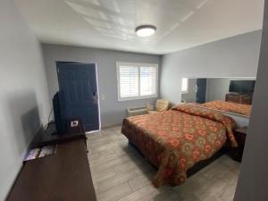 a bedroom with two beds and a television in it at Mesa Oasis Inn & Motel in Mesa