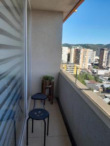 d'un balcon avec deux tabourets et vue sur la ville. dans l'établissement Depto estudio 1510 Edif centro blanco con estacionamiento, à Temuco