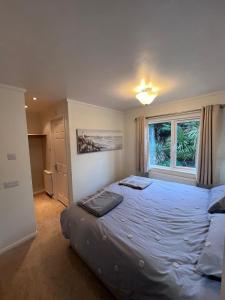 Un dormitorio con una cama grande y una ventana en The Warren Holiday Park - Family Chalet, en Abersoch