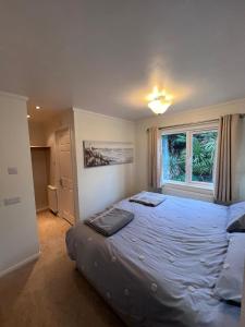 a bedroom with a large bed and a window at The Warren Holiday Park - Family Chalet in Abersoch