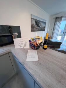 a kitchen counter with a bottle of beer and a basket of food at The Warren Holiday Park - Family Chalet in Abersoch