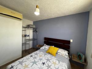 een slaapkamer met een bed met een blauwe muur bij Las mejor opción Departamento Zona Diamante - Puente del Mar in Acapulco