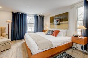 una camera da letto con un grande letto bianco con tende blu di Auberge Handfield et Spa a Saint-Marc-sur-Richelieu