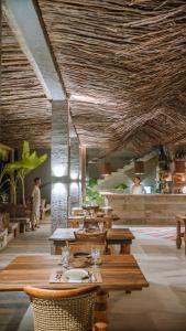 a restaurant with wooden tables and people in the background at Zai Patacho in Pôrto de Pedras