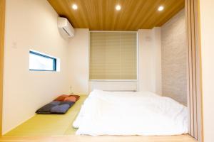 a bedroom with a white bed and a window at Queens Park CK VILLAGE Niseko Hirafu in Kutchan