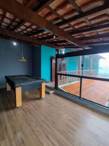 a ping pong table in a room with a balcony at Casa em Miguel Pereira in Miguel Pereira