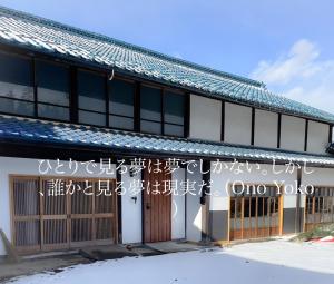 un edificio con scritte su un lato di [貸切り] 220㎡ 月のワルツ 108年前の高級古民家 a Komoro