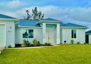 a house with a green lawn in front of it at New house with canal view in Cape Coral in Cape Coral