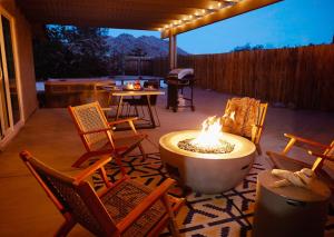 a fire pit on a patio with chairs and a table at Live Centered with Hot Tub, Fire Pit In Joshua Tree home in Joshua Tree