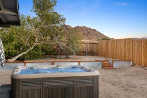 a hot tub in a yard next to a fence at Live Centered with Hot Tub, Fire Pit In Joshua Tree home in Joshua Tree