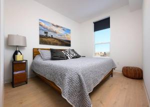 a white bedroom with a bed and a window at Stylish SoBo Condo - Steps to Main St in Bozeman