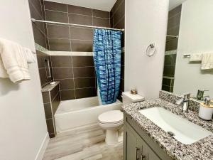 een badkamer met een wit toilet, een bad en een wastafel bij New house with canal view in Cape Coral in Cape Coral