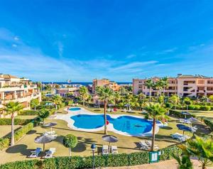 an aerial view of a resort with two pools and palm trees at Casares Beach Golf Apartment With Private Garden Direct Pool Access in Casares