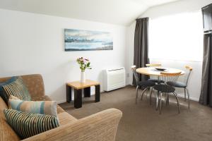 uma sala de estar com um sofá e uma mesa em FYFFE on Riccarton em Christchurch